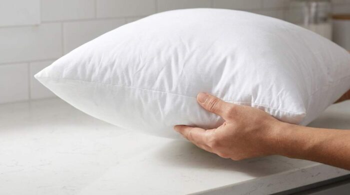 Fluffing clean goose feather pillow insert after drying